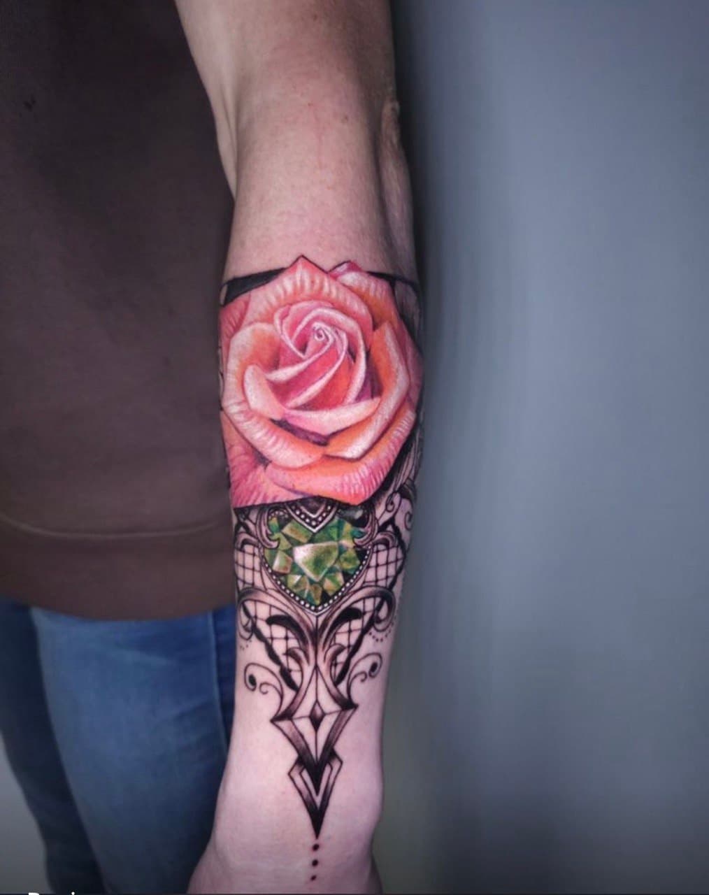 Pink rose and ornamental blackwork forearm tattoo