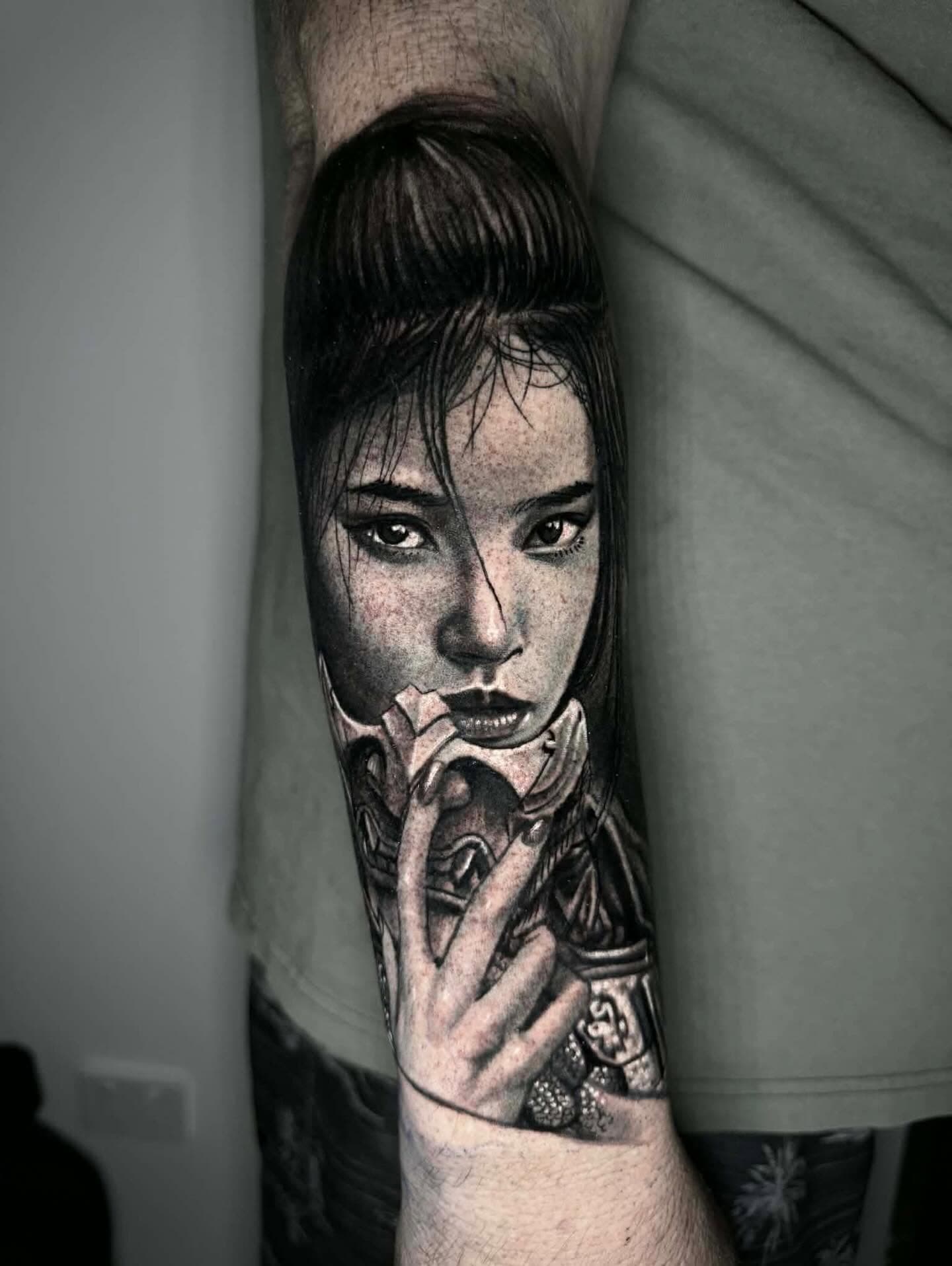 Detailed black and grey portrait of a woman on an upper arm