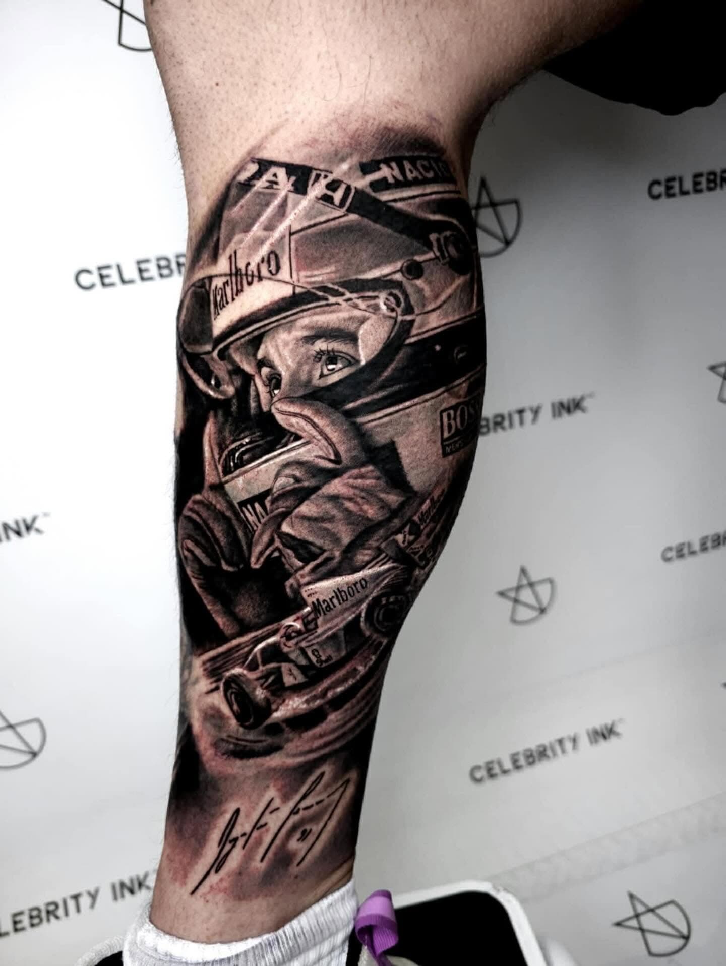 Black and grey racing driver and race car tattoo on an arm